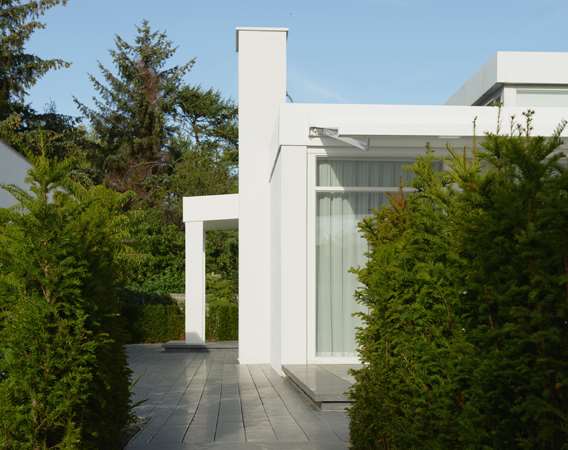 Kubistisk hvidt hus med lange plank i natursten